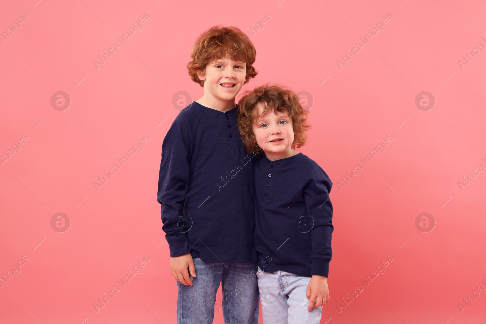 Cute little brothers together on pink background Photo of Cute little brothers together on pink background