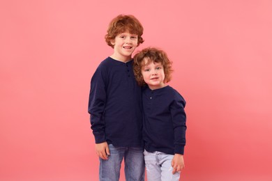 Photo of Cute little brothers together on pink background