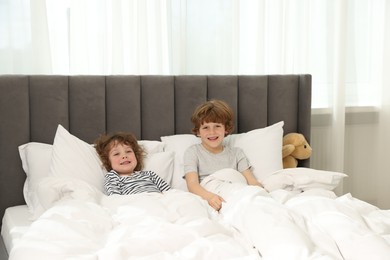 Photo of Cute little brothers laying in bed at home