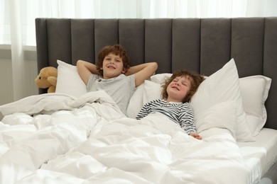 Photo of Cute little brothers laying in bed at home