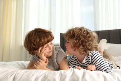 Photo of Cute little brothers laying on bed at home