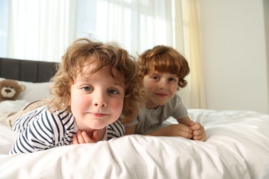 Photo of Cute little brothers laying on bed at home, wide angle