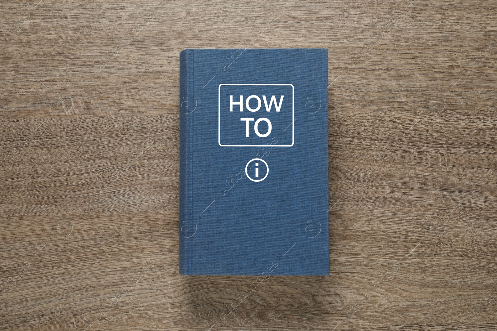 How To book on wooden background, top view. User guide Image of How To book on wooden background, top view. User guide