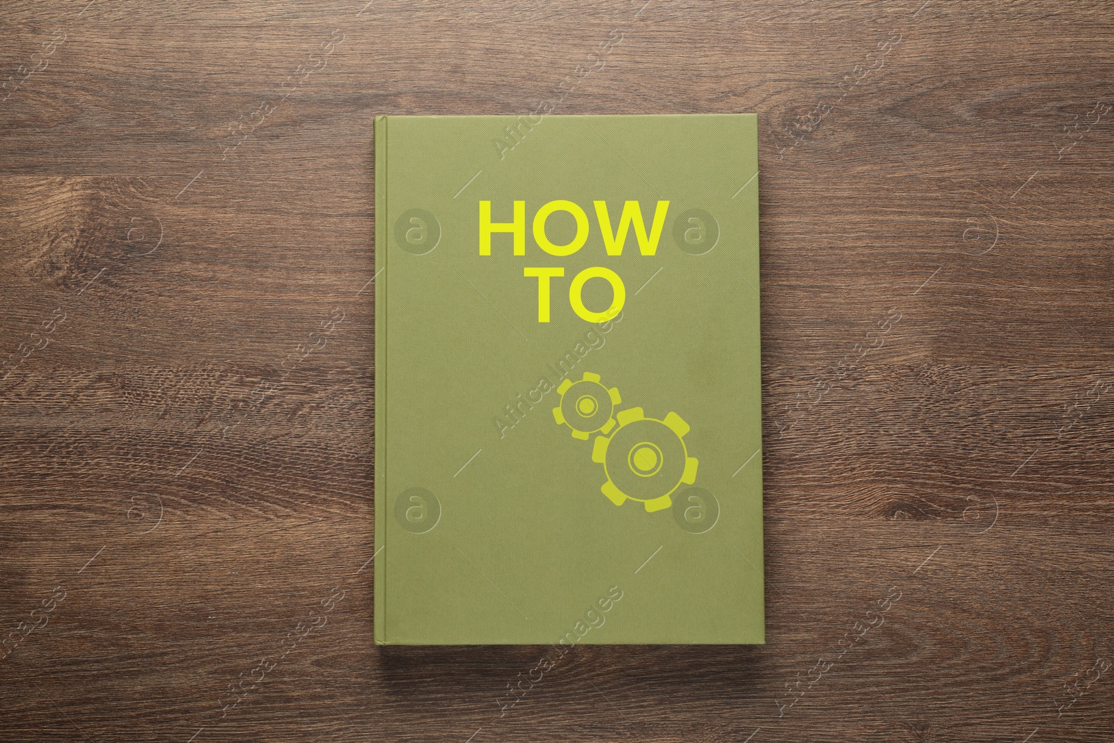 How To book on wooden background, top view. User guide Image of How To book on wooden background, top view. User guide