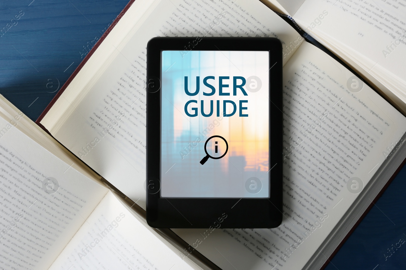 User Guide document open in e-book device and different books on blue wooden table, top view Image of User Guide document open in e-book device and different books on blue wooden table, top view