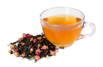 Photo of Delicious herbal tea in glass cup and dry leaves isolated on white
