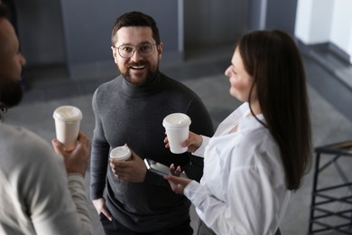 Photo of Colleagues with coffee on stairs in office during break