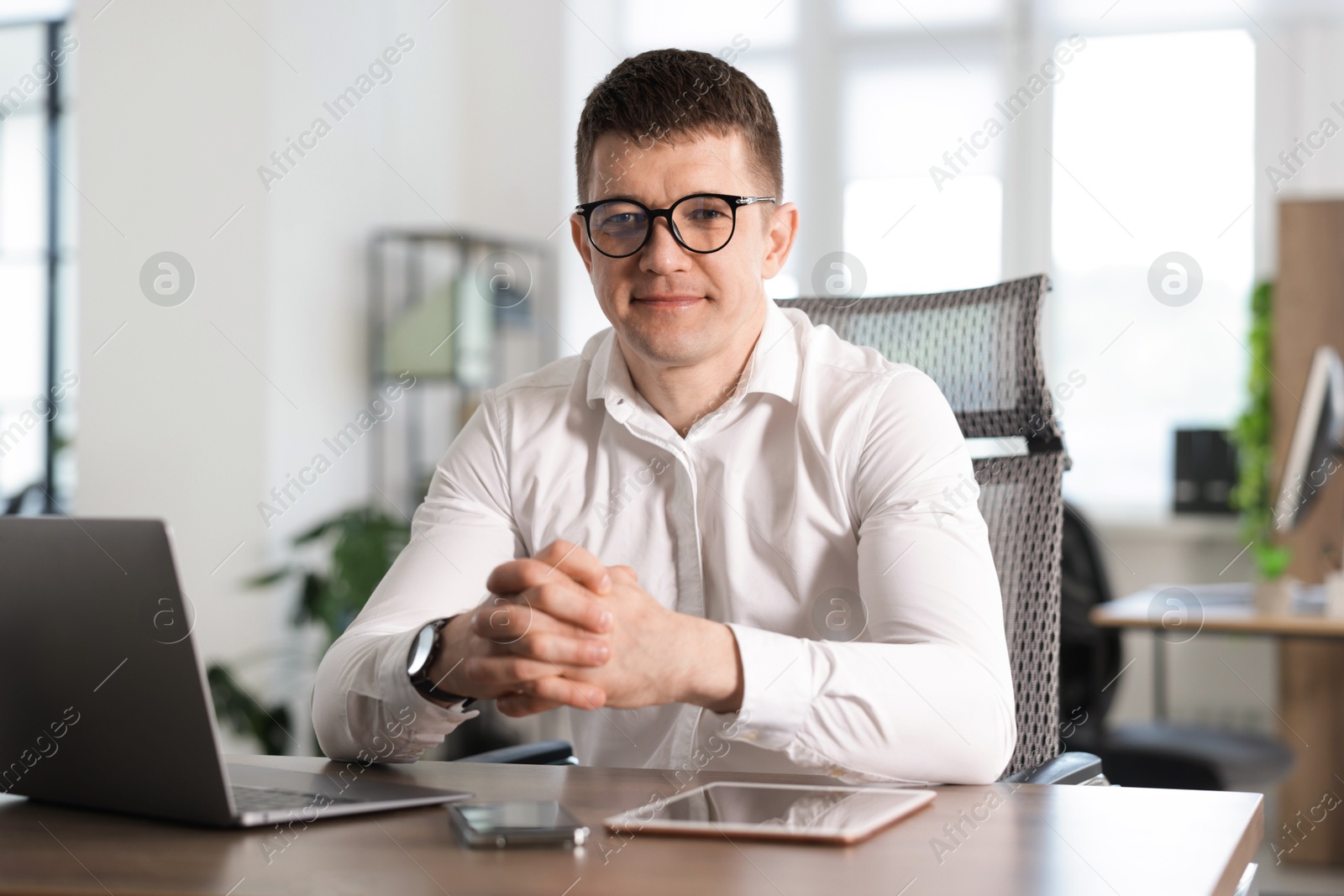 Portrait of handsome man at desk in office Photo of Portrait of handsome man at desk in office