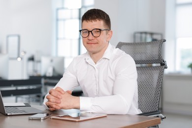 Photo of Portrait of handsome man at desk in office