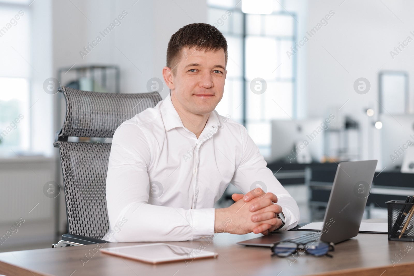Portrait of handsome man at desk in office Photo of Portrait of handsome man at desk in office