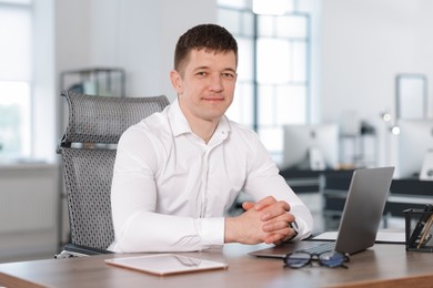 Photo of Portrait of handsome man at desk in office