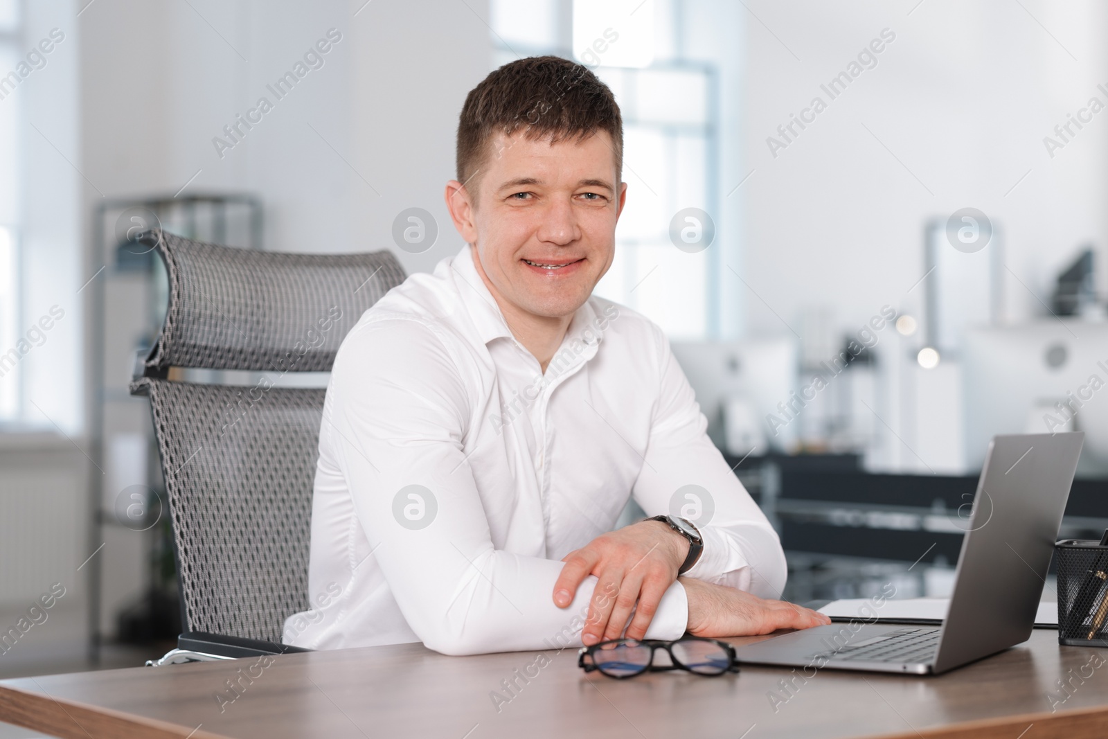 Portrait of handsome man at desk in office Photo of Portrait of handsome man at desk in office