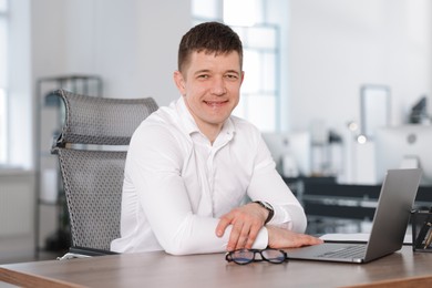 Photo of Portrait of handsome man at desk in office
