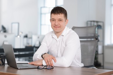 Photo of Portrait of handsome man at desk in office