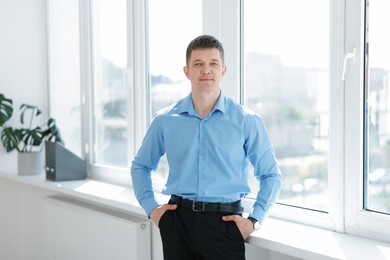 Photo of Portrait of handsome man near window indoors