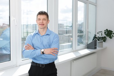 Photo of Portrait of handsome man near window indoors. Space for text