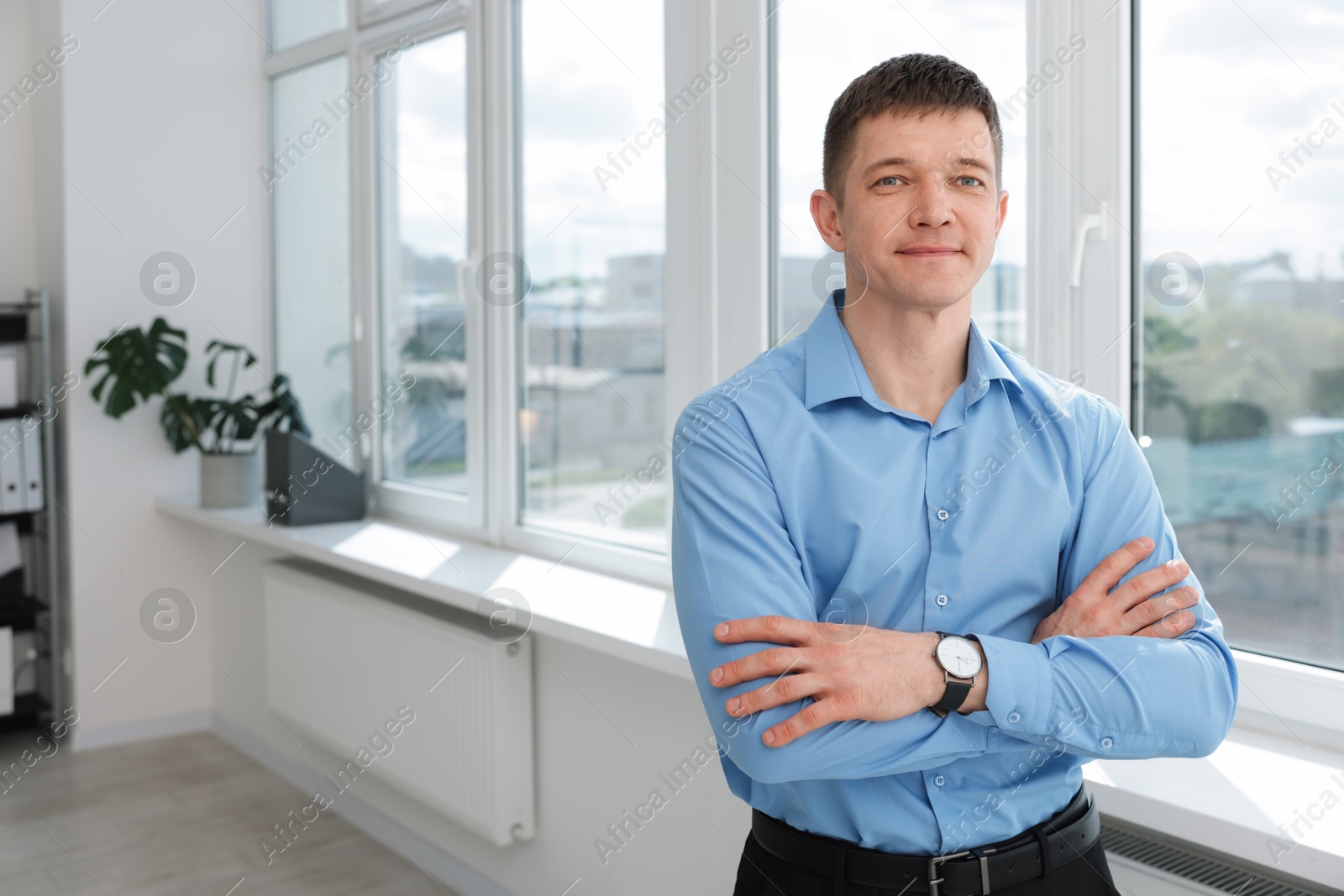 Photo of Portrait of handsome man near window indoors. Space for text