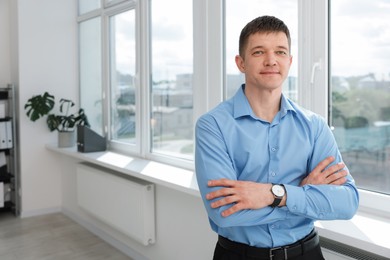 Photo of Portrait of handsome man near window indoors. Space for text