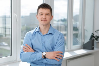 Photo of Portrait of handsome man near window indoors