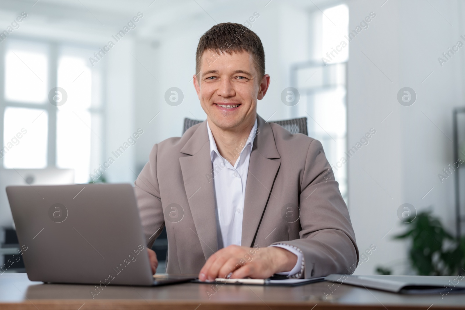 Portrait of handsome man at desk in office Photo of Portrait of handsome man at desk in office