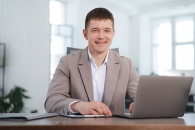Photo of Portrait of handsome man at desk in office