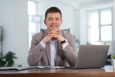 Photo of Portrait of handsome man at desk in office