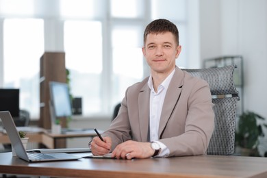 Photo of Handsome man working at desk in office. Space for text