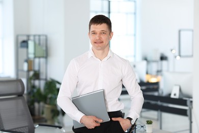 Photo of Portrait of handsome man with folder in office