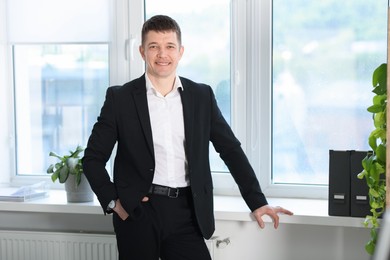 Photo of Portrait of handsome man near window indoors