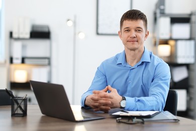 Photo of Portrait of handsome man at desk in office. Space for text
