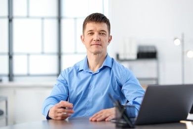 Photo of Handsome man working at desk in office