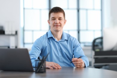 Photo of Handsome man working at desk in office