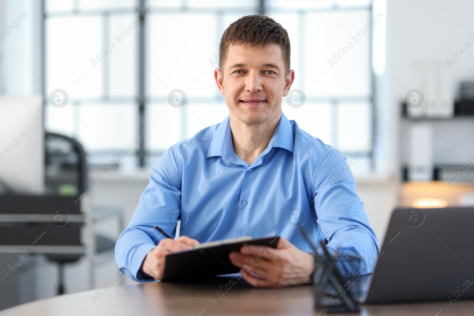 Handsome man working at desk in office Photo of Handsome man working at desk in office