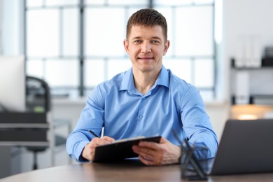 Photo of Handsome man working at desk in office