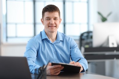 Photo of Handsome man working at desk in office