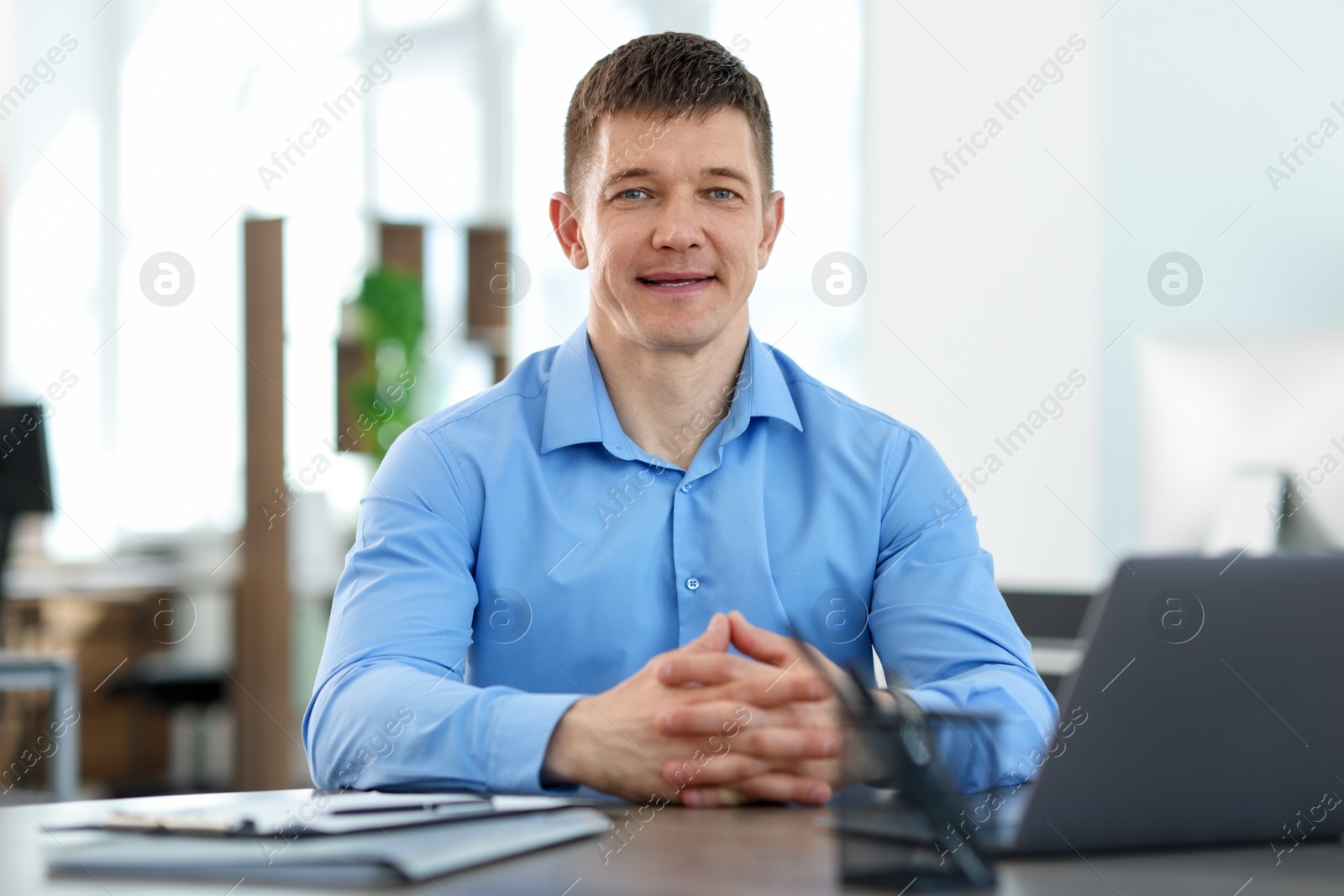 Portrait of handsome man at desk in office Photo of Portrait of handsome man at desk in office
