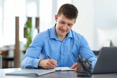 Photo of Handsome man working at desk in office