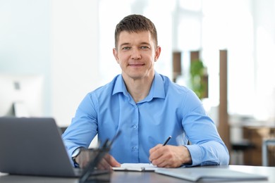 Photo of Handsome man working at desk in office