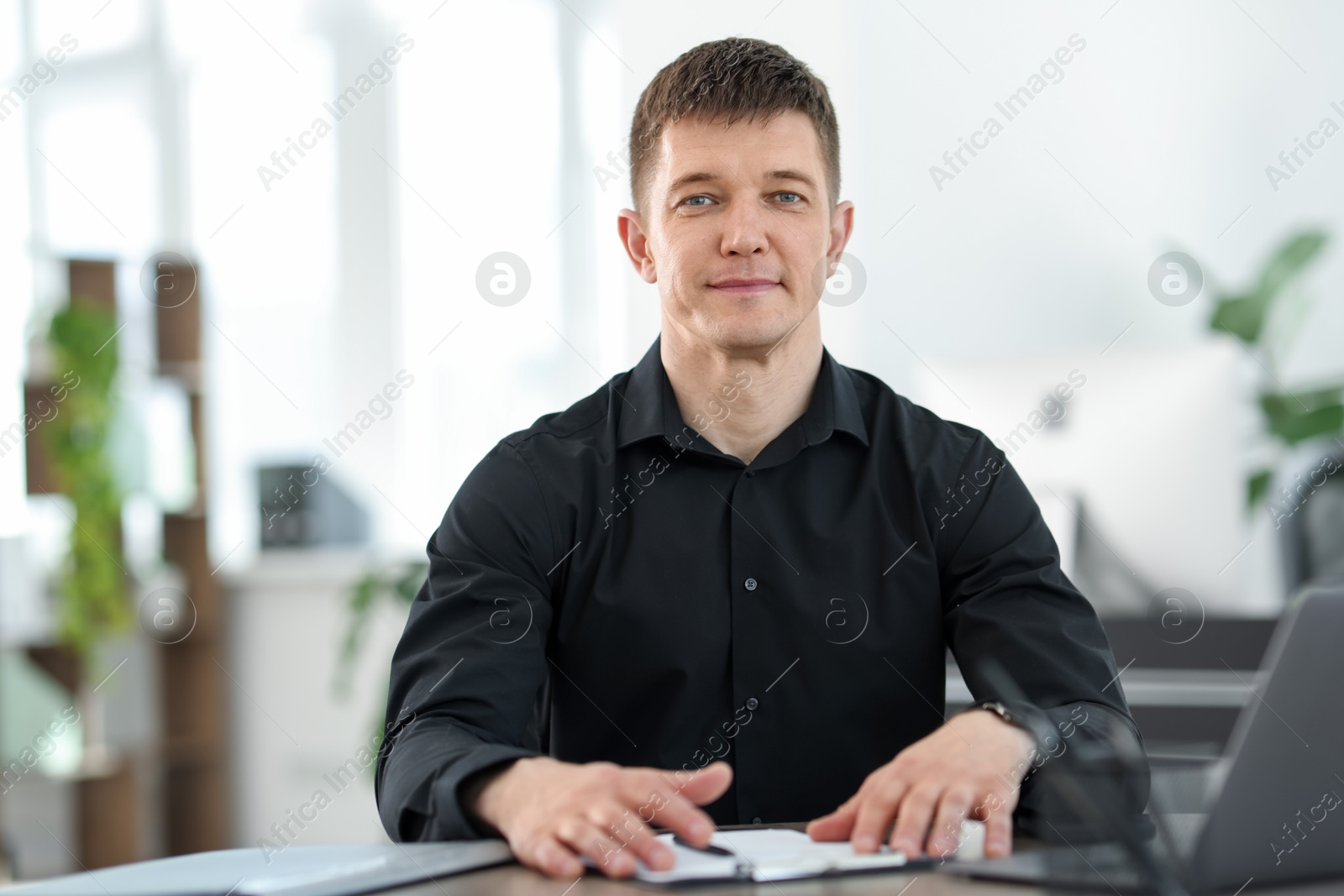 Handsome man working at desk in office Photo of Handsome man working at desk in office