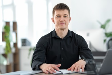 Photo of Handsome man working at desk in office
