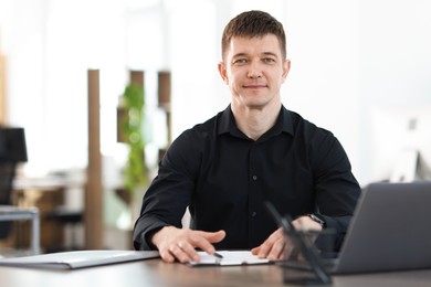 Photo of Handsome man working at desk in office