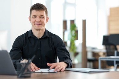 Photo of Handsome man working at desk in office. Space for text