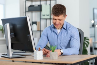 Photo of Handsome man working at desk in office
