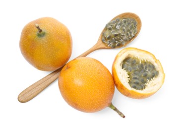 Photo of Ripe passion fruits, seeds, green leaves and spoon isolated on white, top view