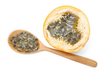 Photo of Ripe passion fruit, seeds and spoon isolated on white, top view