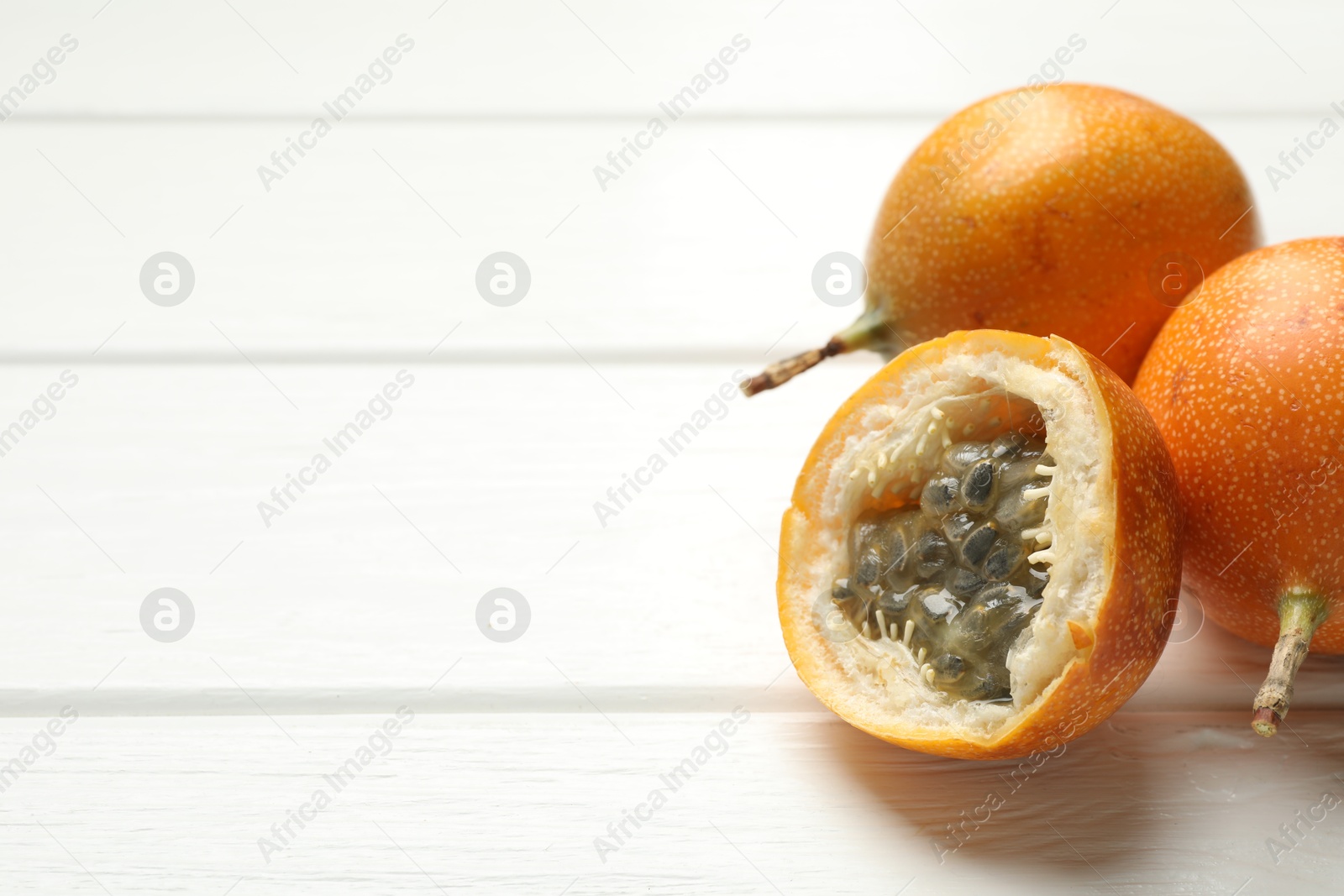 Ripe passion fruits on white wooden table, closeup. Space for text Photo of Ripe passion fruits on white wooden table, closeup. Space for text
