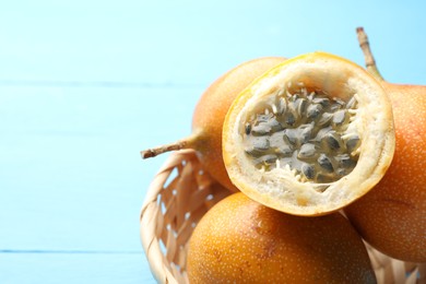 Photo of Ripe passion fruits on light blue table, closeup. Space for text