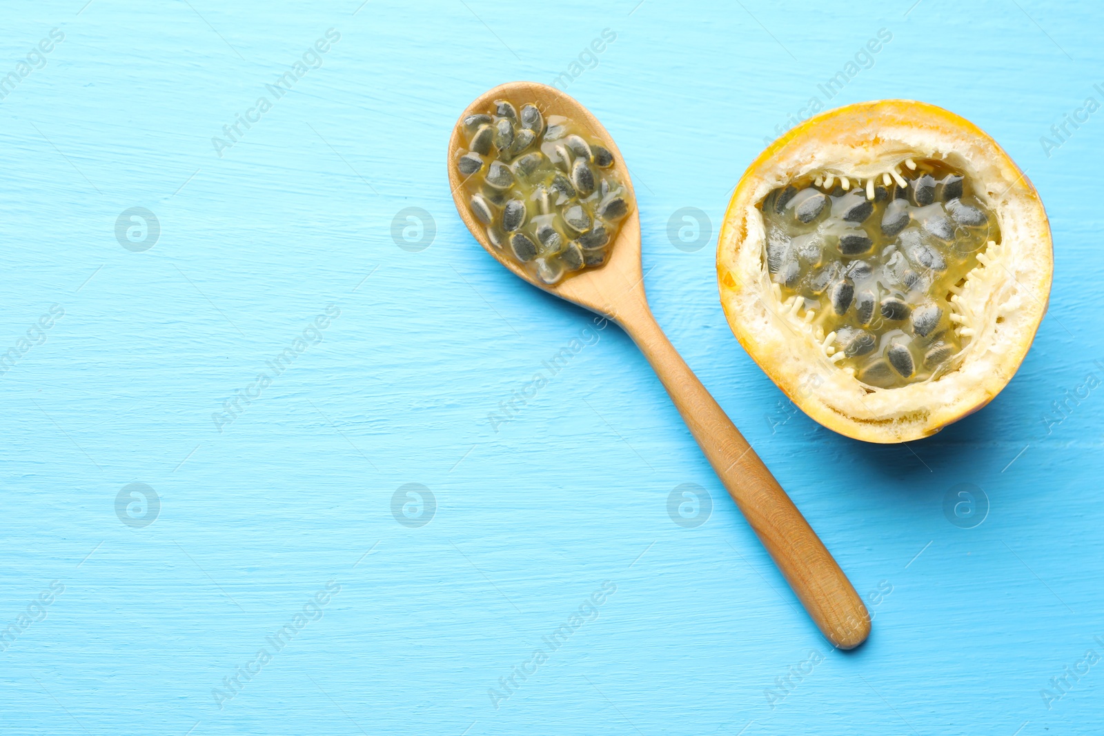 Ripe passion fruit and seeds on light blue wooden table, flat lay. Space for text Photo of Ripe passion fruit and seeds on light blue wooden table, flat lay. Space for text