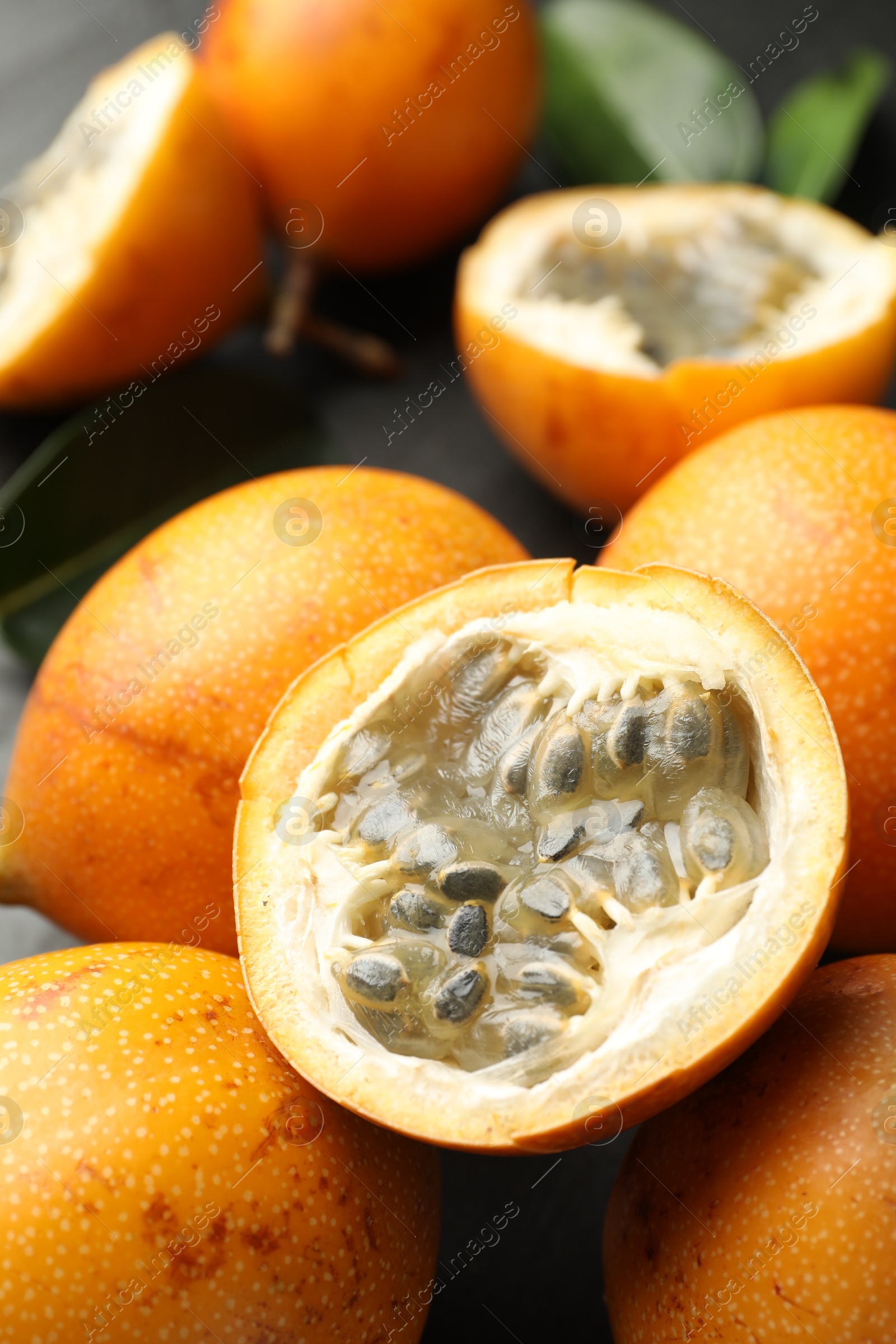 Ripe passion fruits and leaves on table, closeup Photo of Ripe passion fruits and leaves on table, closeup