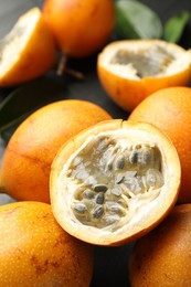 Photo of Ripe passion fruits and leaves on table, closeup